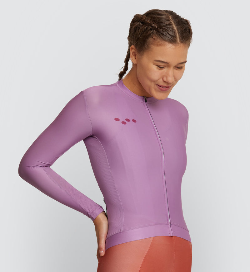  Front view of female cyclist wearing Mauve Classic Long Sleeve Cycling Jersey, showcasing breathable fabric and secure silicone hem