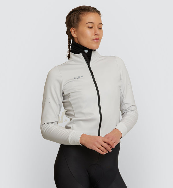 Front view of female cyclist wearing Chalk Thermal Cycling Jacket, showcasing the high stand collar and sleek design