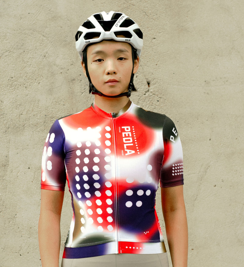 Model wearing the COLOUR THEORY Women's Classic Cycling Jersey in Spectrum White, highlighting a stylish fit, breathable fabric, and low-cut collar for cycling.