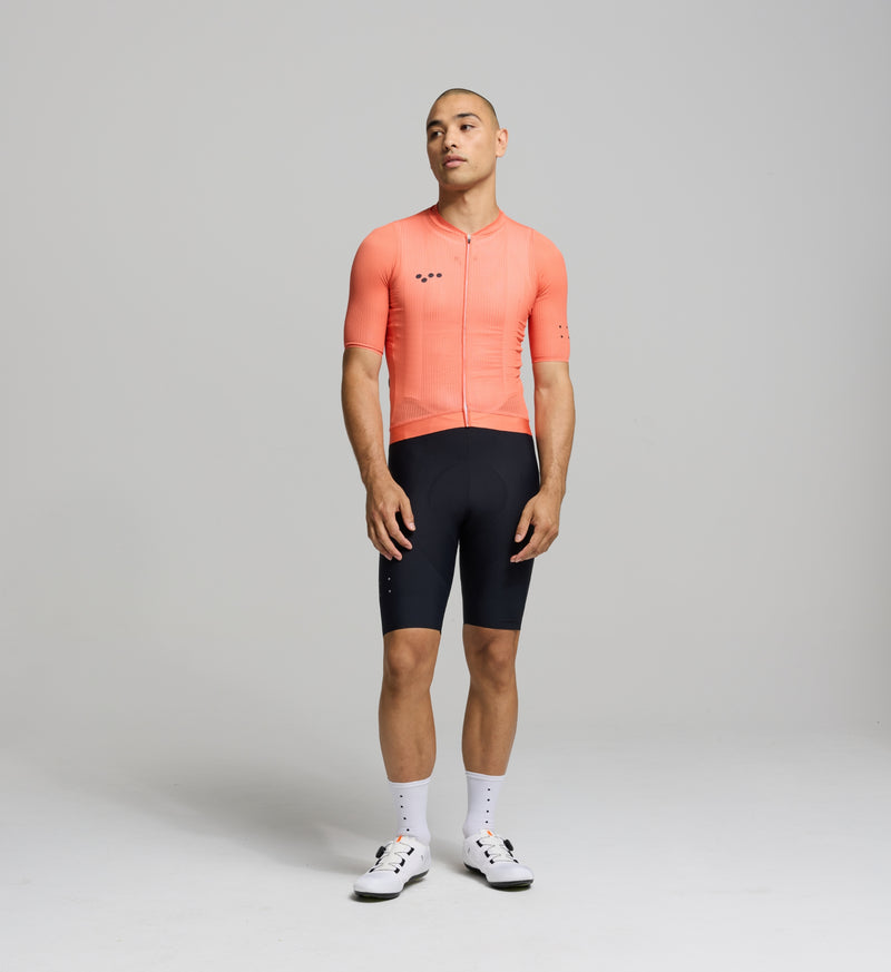 Front view of male cyclist in apricot Air Jersey – aerodynamic cut with strategic chest and sleeve mesh for airflow, comfort, and moisture control during hot-weather efforts.