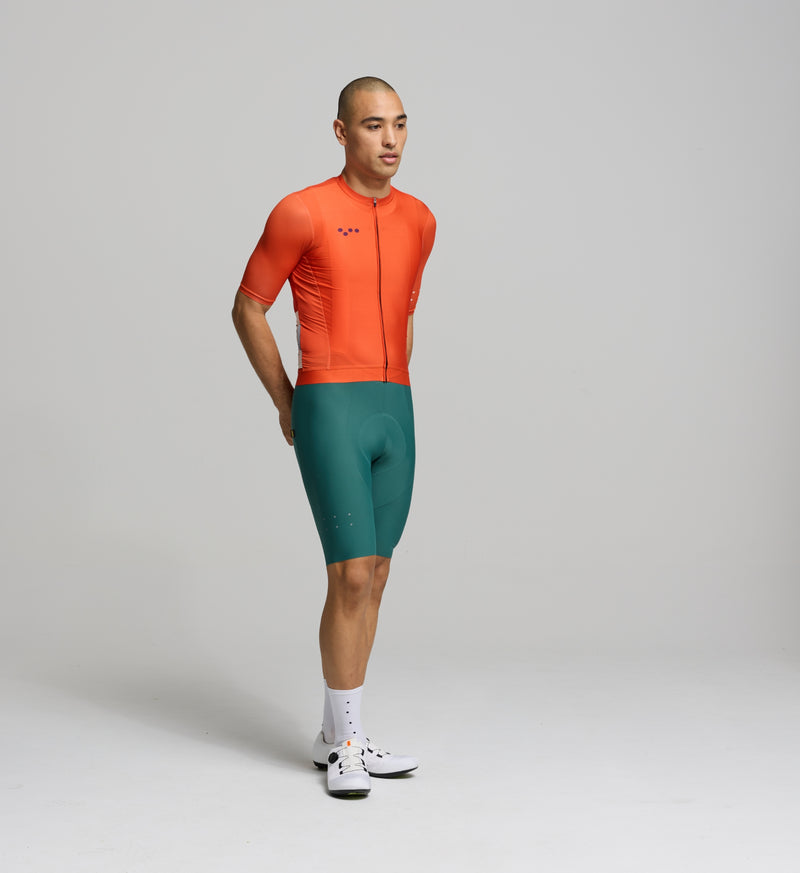 Front view of male cyclist in amber Classic Jersey – sleek fit with extended sleeves and low-cut collar for a modern silhouette and aerodynamic road performance.