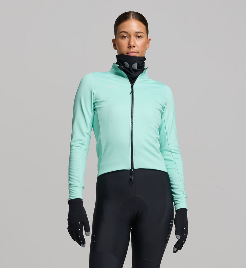 Front view of female cyclist wearing mint winter cycling jacket – minimalist silhouette, thermal performance knit with membrane technology, and waterproof two-way zipper.