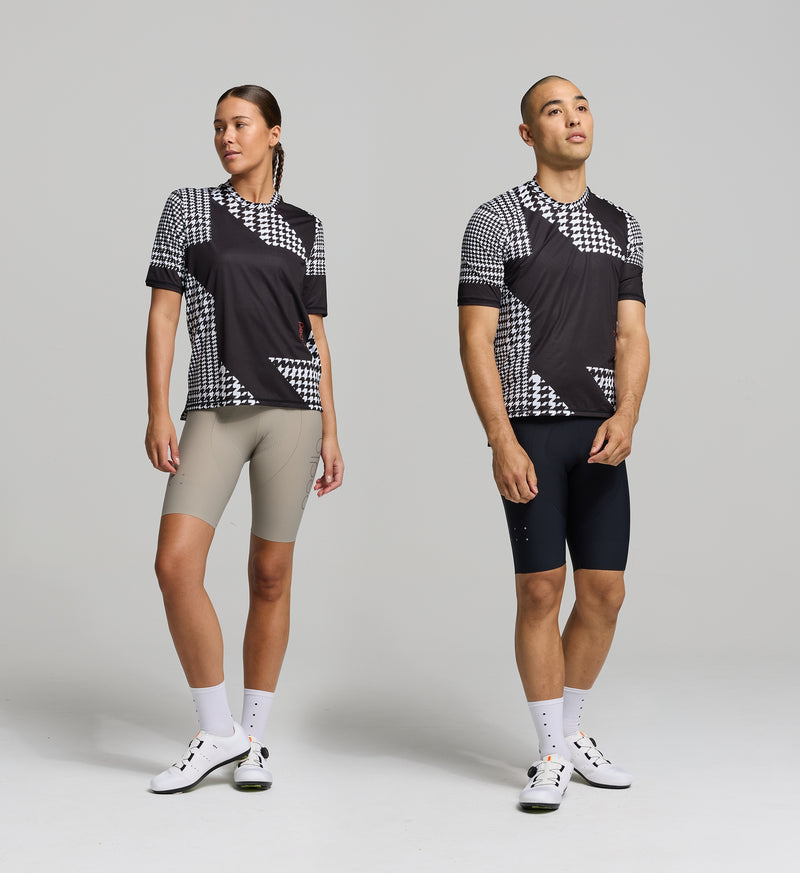 Cyclists wearing the HoundsKNIT Tech Tee - Black OFFSET, showcasing its relaxed fit, stretch fabric, and high-performance breathability.