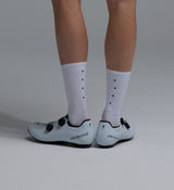 Pedla lightweight porcelain white merino wool cycling socks, mid-calf 6in cuff, moisture-wicking, temperature-regulating, odor-resistant merino blend with arch support and anatomical left/right fit, shown with white road cycling shoes