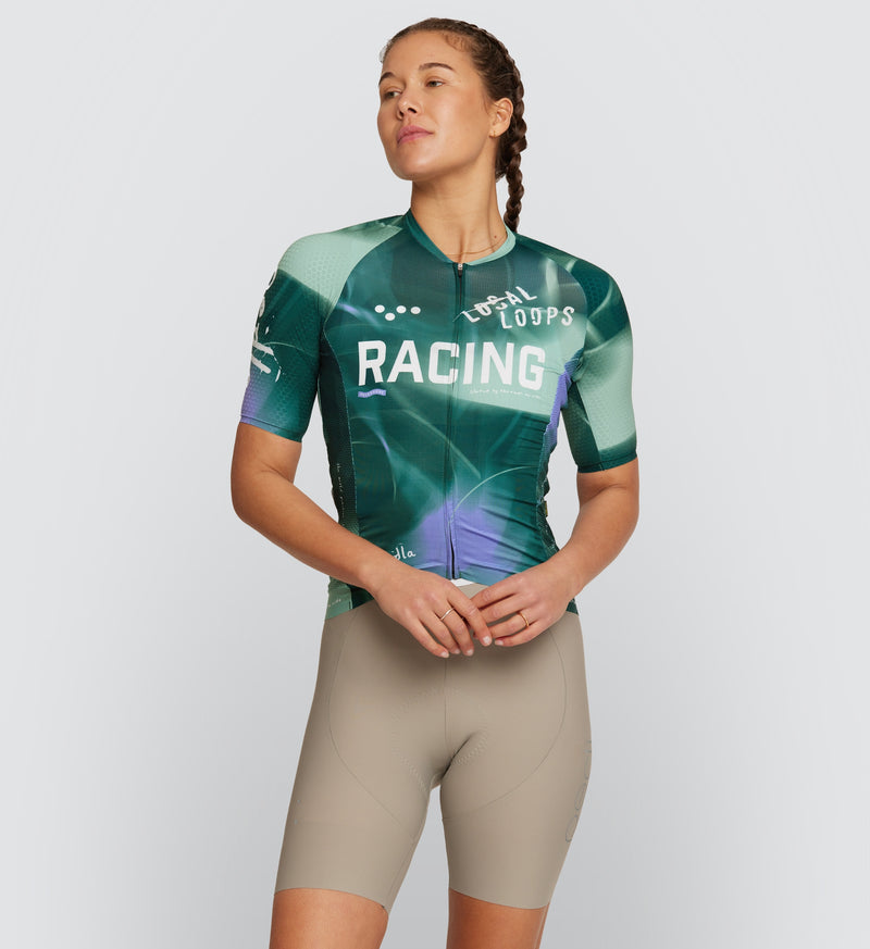 Front view of model wearing LOCAL LOOPS Women's Pro Pursuit 2.0 Cycling Jersey in Race Pine, highlighting the race-fit design, lightweight construction, and breathable mesh underarm panels that provide ventilation and performance during intense cycling rides.