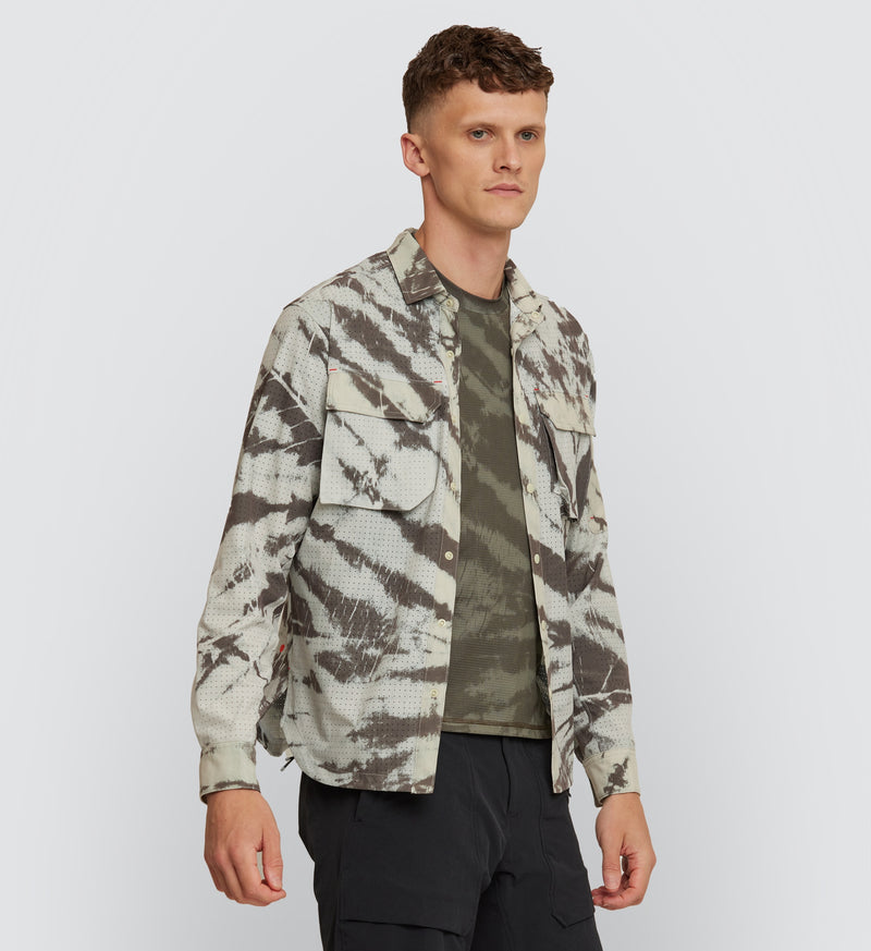 Front view of a model wearing the Mono Tie Dye Off Grid Cargo Shirt, showcasing the relaxed fit and airflow-enhancing perforated fabric for cyclists.