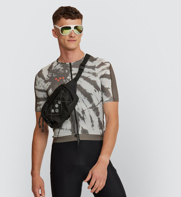 Model sporting the Mono Tie Dye Off Grid Men's Gravel Cycling Jersey, focusing on the jersey's form-fitting design with ventilating mesh panels for enhanced air flow.
