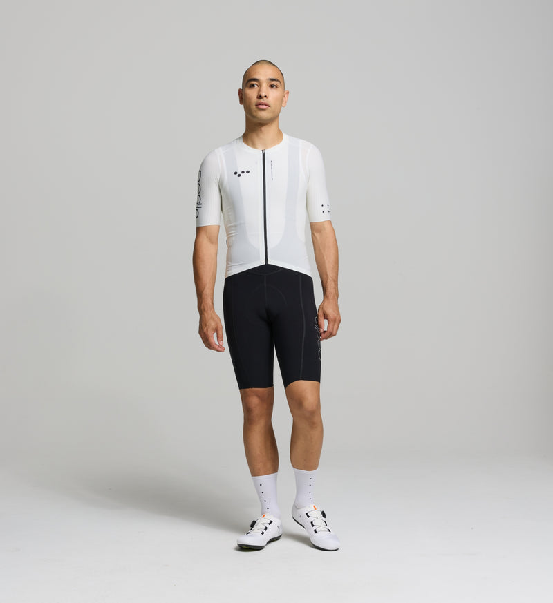 Cyclist wearing the Pursuit AIR Cycling Jersey in Porcelain, highlighting its aerodynamic race fit, moisture-wicking fabric, and UPF 35+ sun protection for summer cycling.