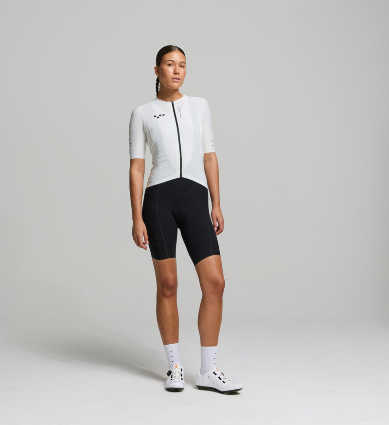 Cyclist wearing the Women’s Pursuit AIR Cycling Jersey in Porcelain, showcasing its aerodynamic fit, moisture-wicking fabric, and UPF 35+ sun protection for summer cycling.