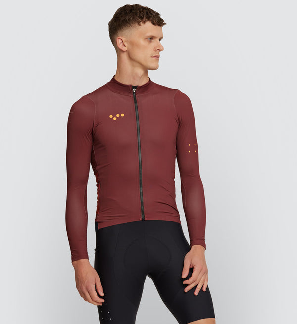 Front view of cyclist in Rust Midweight Long Sleeve Jersey, showcasing form-fitting design