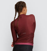 Back view highlighting the functionality and style of the Women's Thermal Long Sleeve Jersey in Rust, with rear pockets and reflective details