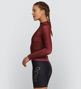 Side view of Women's Rust Thermal Long Sleeve Cycling Jersey featuring hem gripper and articulated panel design for optimal movement