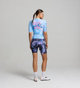 Back view of a female cyclist wearing the DENIM / Women's Classic Cycling Jersey in Blue Fade, with a silicone hem gripper for secure, all-day comfort.