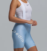 Pedla Women's SuperFIT 2.0 powder blue cycling bib shorts close-up, high-compression Italian fabric, breathable mesh top with white straps, Elastic Interface chamois, seamless non-stitched cuff, aerodynamic fit and reflective logos