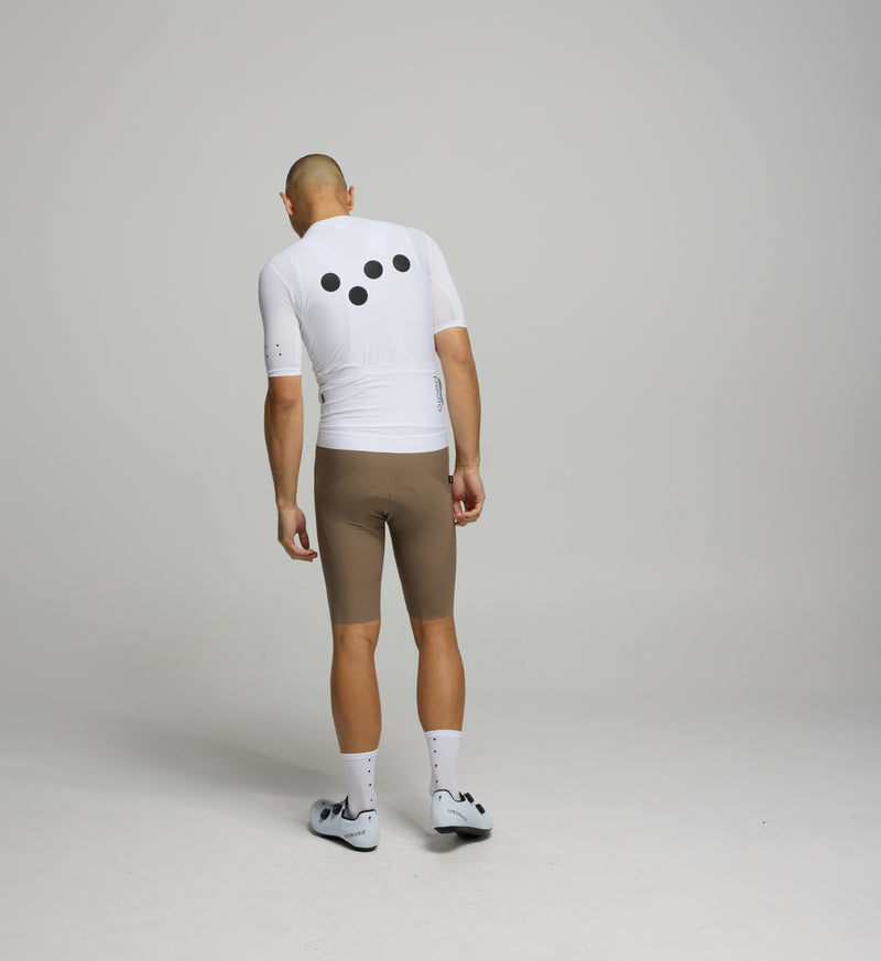 Back view of male cyclist in Core White Classic Jersey – form-fitting silhouette with extended sleeves and low collar designed for aerodynamic road performance.
