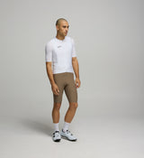 Side view of male cyclist in Core White Classic Jersey – form-fitting silhouette with extended sleeves and low collar designed for aerodynamic road performance.