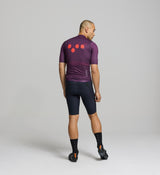 Rear image of aubergine gilet – featuring three reinforced back pockets for ride essentials, breathable mesh panel, and reflective logo to enhance visibility in low light.