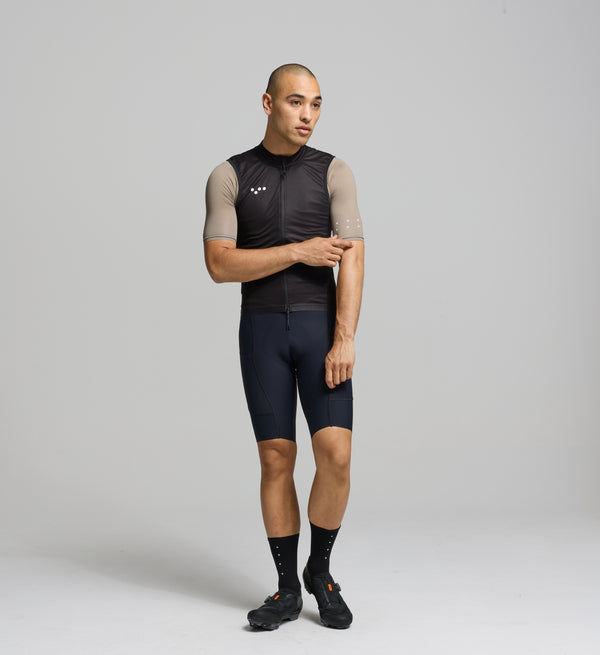 Front view of male cyclist in black Classic LITE Gilet – minimalist silhouette with SAB two-way zip, wind-blocking fabric, and reflective front detail for early starts and late finishes.