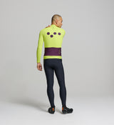 Rear view of electric lime cycling jersey – four-pocket system with side-wrap access, reinforced rear panel, and silicone hem gripper for secure fit on cool-season endurance rides.