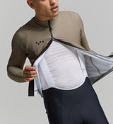 Close-up of thermal sandstone fabric and SAB zipper – soft brushed knit with breathable finish, two-way zipper for mid-ride ventilation, and premium seam detailing.
