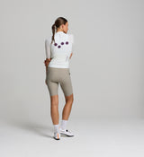 Rear view of Pedla Air Jersey in porcelain on female rider – showcasing three reinforced back pockets that hold shape, combined with breathable back panel mesh for temperature regulation during high-intensity rides.
