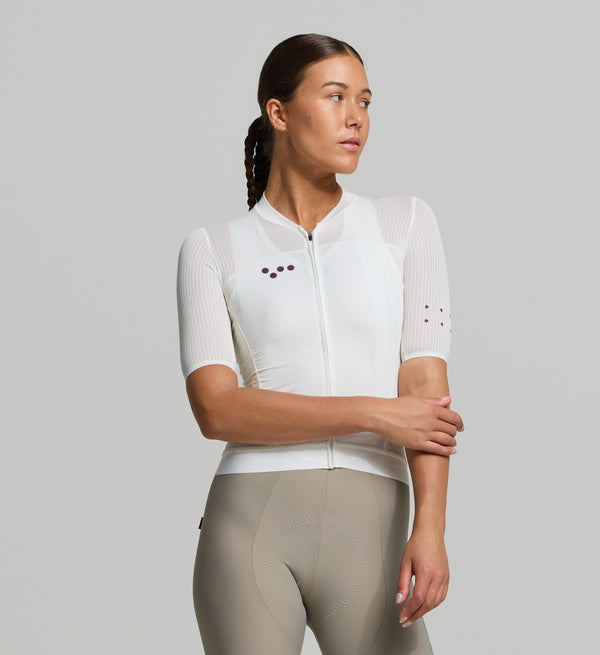 Front view of female cyclist wearing Pedla’s Women's Air Jersey in porcelain – form-fitting aerodynamic cut with high airflow mesh panels across the chest and sleeves for superior cooling in peak summer conditions.