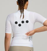 Back view of female cyclist in Core White Classic Jersey – extended sleeves, low-cut collar, and form-fitting silhouette designed for comfort and road performance.