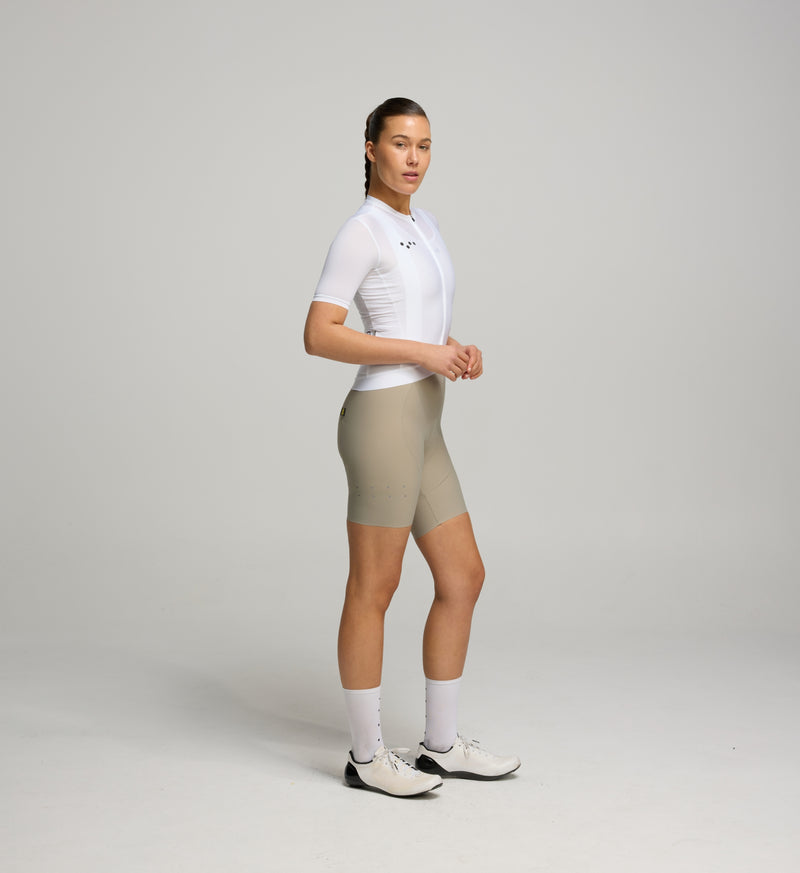Side view of female cyclist in Core White Classic Jersey – extended sleeves, low-cut collar, and form-fitting silhouette designed for comfort and road performance.