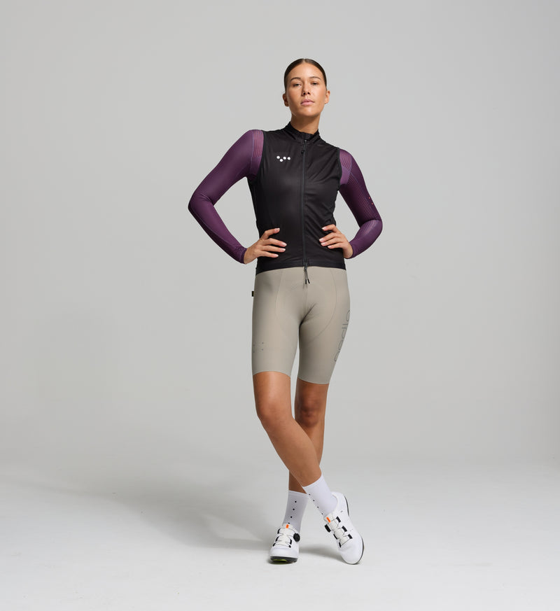 Front view of female cyclist in black Classic LITE gilet – minimalist performance fit with wind-blocking front panel, SAB two-way zipper, and subtle reflective chest detail.