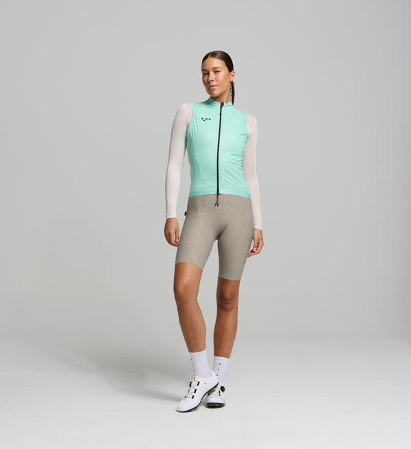 Front view of female cyclist in mint Classic LITE gilet – minimalist fit with wind-blocking fabric, SAB two-way zipper, and reflective chest detailing for visibility on early starts.