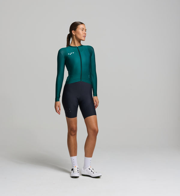 Front view of female cyclist in pine Classic Long Sleeve Jersey – sleek, contoured fit with extended sleeves, inspired by LunaLUXE styling and built for versatile cycling conditions.