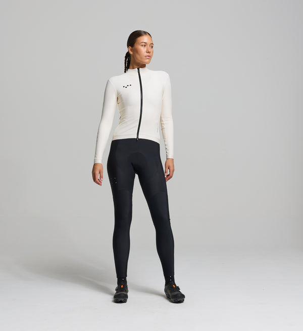 Female cyclist in almond thermal jersey – sculpted front view with articulated sleeves and soft thermal fabric for warmth and comfort on winter rides.
