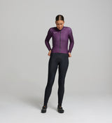 Female cyclist in aubergine thermal jersey – contoured front fit with articulated sleeves, designed for warmth, comfort, and movement during cool-to-cold rides.