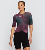 Front view of female cyclist wearing Interweave Pine Pro Pursuit 2.0 Jersey, highlighting the heat-welded sleeve hems and engineered fit