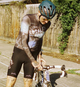 Front view of model wearing LOCAL LOOPS Men's Long Sleeve Cycling Jersey in Club Grey, showcasing a sleek, form-fitting design with extended sleeve length, breathable fabric, and silicone gripper hem for secure fit and comfort on road rides.