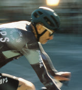 Close-up view of LOCAL LOOPS Men's Long Sleeve Cycling Jersey in Club Grey on model, detailing the breathable SPF 50 fabric, moisture-wicking properties, and four-way stretch for enhanced airflow, flexibility, and comfort during long road rides and training.
