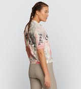 Side view of LOCAL LOOPS Women's Classic Cycling Jersey in Club Almond on model, showcasing the ergonomic fit, breathable fabric, and silicone gripper hem that provide a secure fit, optimal ventilation, and moisture-wicking comfort during bike rides.