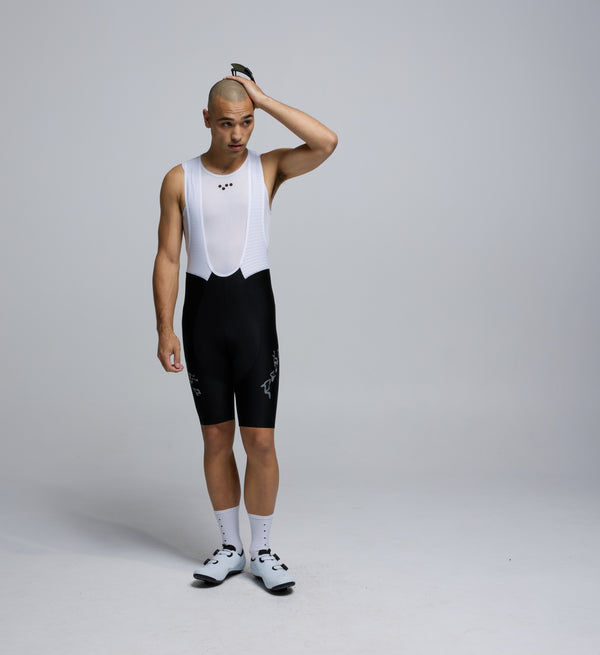 Front view of male cyclist wearing black Training Bib Shorts from the Lost in Nature collection, highlighting sleek cut and seamless cuffs.