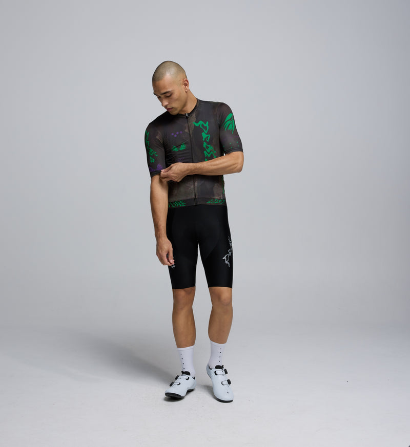 Front view of male cyclist wearing the Acid Black jersey, highlighting low-cut collar, performance fit, and sleek design.