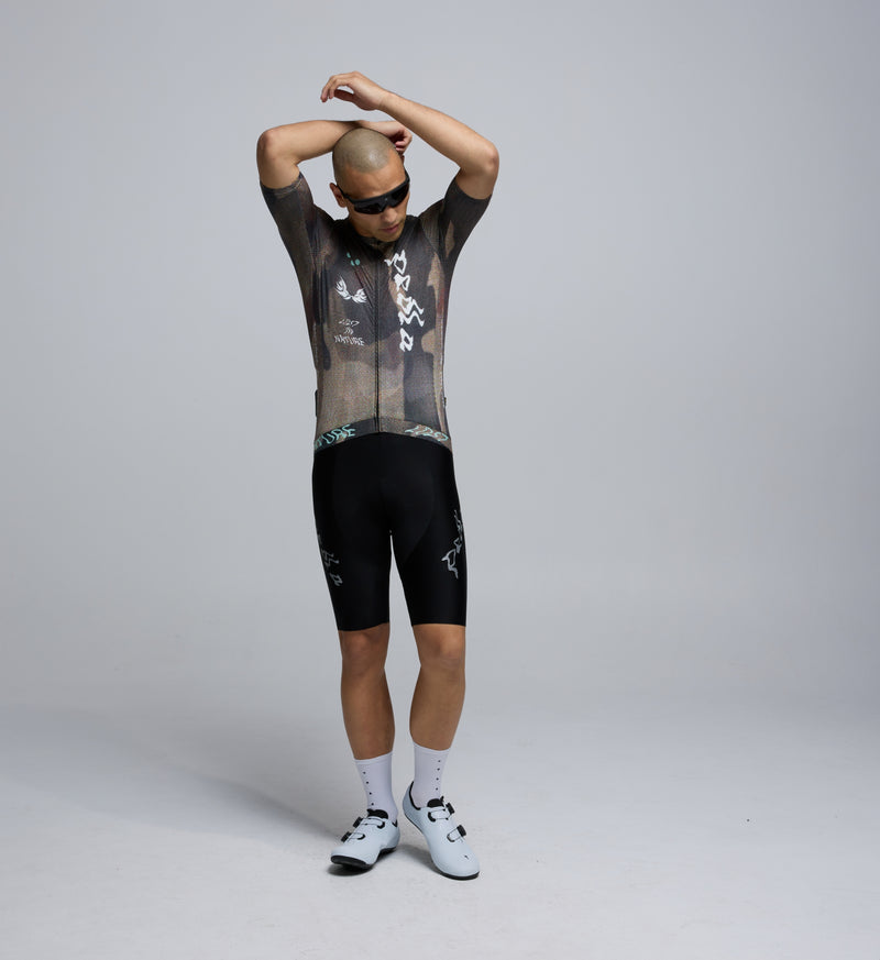 Front view of male cyclist in Dusty Training Jersey, highlighting low-profile collar, contoured cut, and extended sleeves.