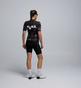 Back view of Women’s Training Jersey – Wild Forest, featuring rear pockets, reflective logo detail, and moisture-wicking recycled fabric.