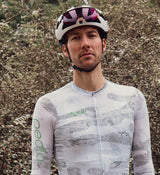 Close-up view of the NatureCAMO Men's Long Sleeve Cycling Jersey in Sketch White on the model, detailing the UPF/SPF 30+ sun protection, microfiber fabric, and four-way stretch fit that supports moisture management and comfort during any cycling activity.