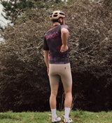 Back view of the NatureCAMO Men's Cycling Jersey in Acid on model, showcasing breathable perforated panels and ergonomic design for comfort and performance during intense road cycling or training rides.