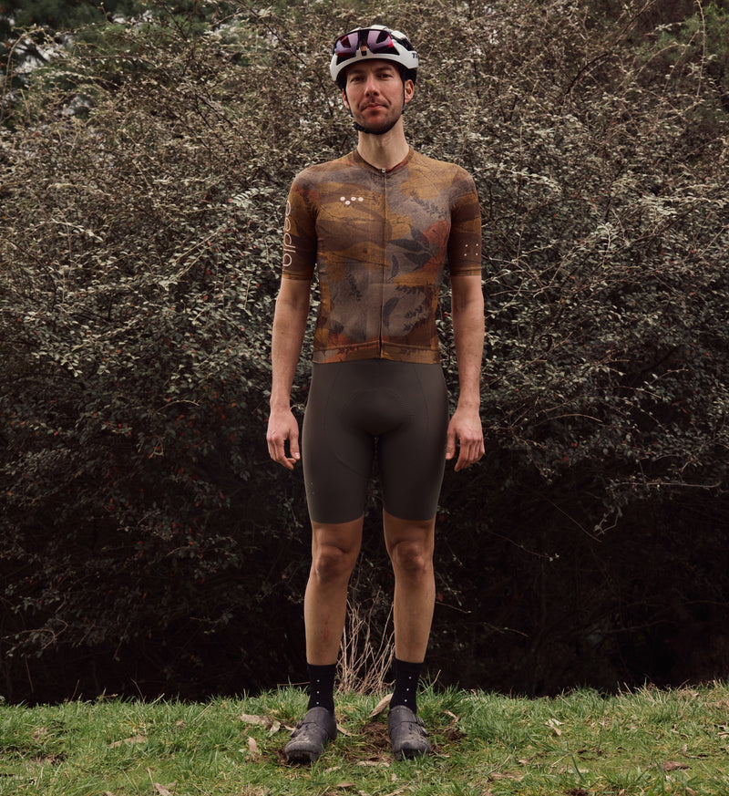 Front view of model wearing NatureCAMO Men's Cycling Jersey in Auburn, showcasing its form-fitting design, low-cut collar, and moisture-wicking fabric for comfort and flexibility during all-season cycling.