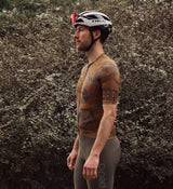 Side view of the NatureCAMO Men's Cycling Jersey in Auburn on model, highlighting the extended sleeve length, ergonomic fit, and breathable perforated panels for enhanced airflow during road rides or training sessions.