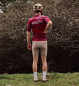 Back view of model wearing NatureCAMO Men's Cycling Jersey in Deep Pink, highlighting the durable, moisture-wicking fabric and tailored fit that supports breathability and freedom of movement during road cycling or commuting.