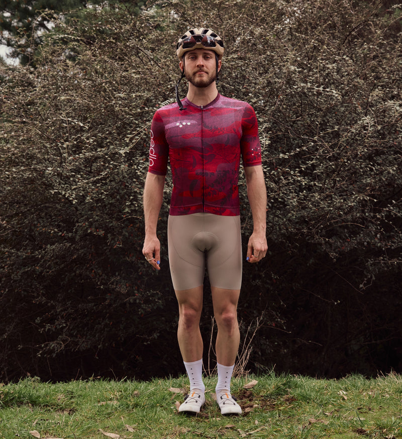 Front view of model wearing NatureCAMO Men's Cycling Jersey in Deep Pink, highlighting the form-fitting design, extended sleeve length, and low-cut collar for a comfortable and flexible fit during road rides and intense training sessions.