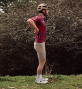 Side view of NatureCAMO Men's Cycling Jersey in Deep Pink on model, showcasing the ergonomic fit, silicone gripper hem, and breathable fabric panels that provide airflow and comfort during long cycling sessions and training circuits.