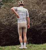 Back view of NatureCAMO Men's Cycling Jersey in Sketch White on model, showcasing the lightweight, breathable fabric and tailored design for maximum airflow and support during long cycling rides or training sessions.