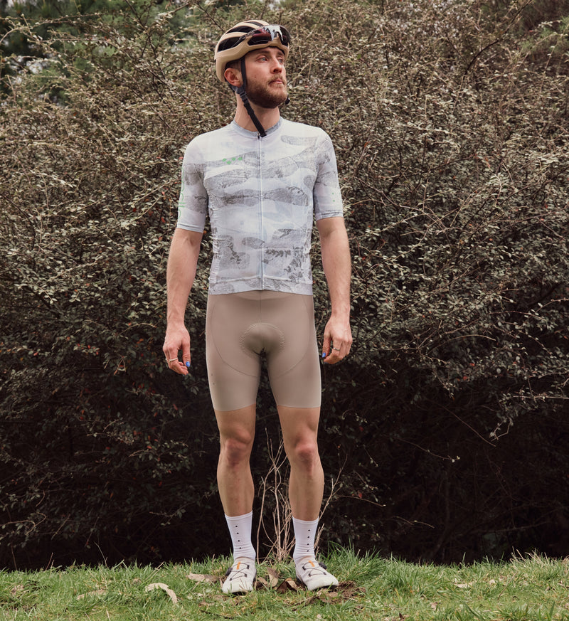 Front view of model wearing NatureCAMO Men's Cycling Jersey in Sketch White, showing the form-fitting design, low-cut collar, and extended sleeve length for an optimal fit during road rides, training, or bike commutes.